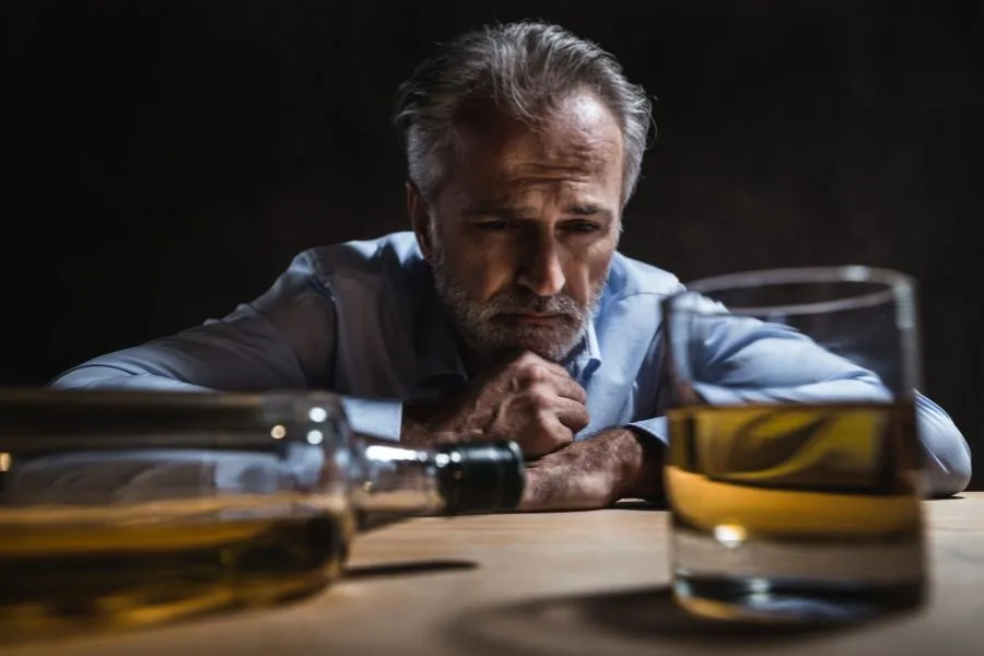 Человек, смотрящий в окно с ожиданием, символизирующий отложенную жизнь